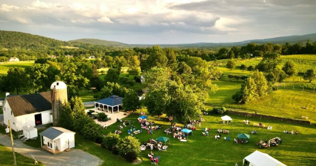 Aerial view of 868 Estate Vineyards with its barn, event lawn, and vineyard landscape at golden hour