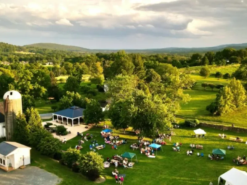 Aerial view of 868 Estate Vineyards with its barn, event lawn, and vineyard landscape at golden hour