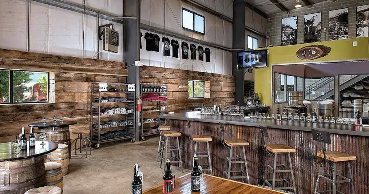 Interior of Adroit Theory Brewing Company with its taproom bar, stools, and industrial tasting room space