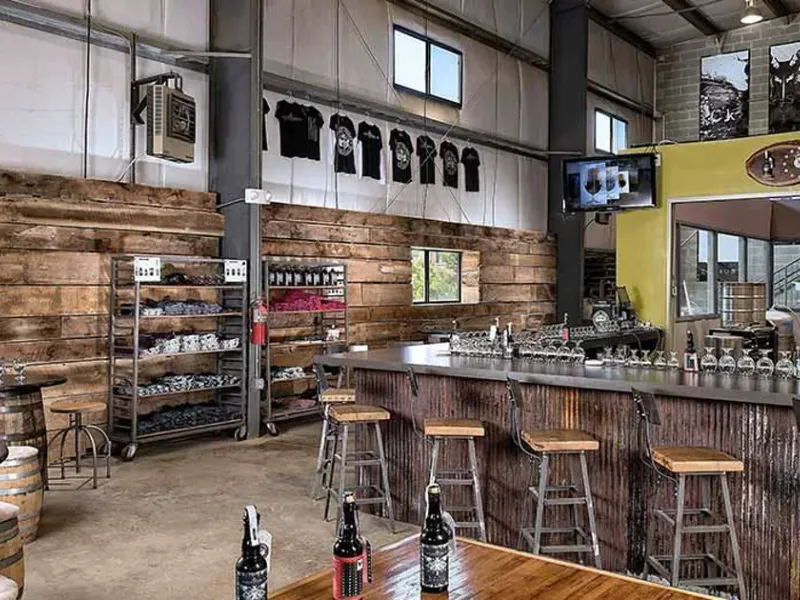 Interior of Adroit Theory Brewing Company with its taproom bar, stools, and industrial tasting room space