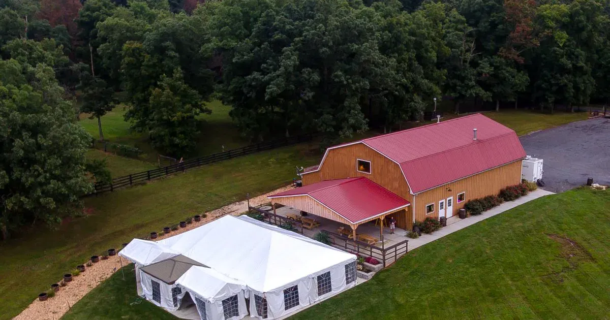 Aerial view of Barnhouse Brewery with its red-roofed barn building and tented lawn space