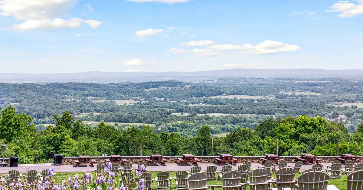 Terraced seating at Bear Chase Brewing Company overlooking a wide Bluemont valley view