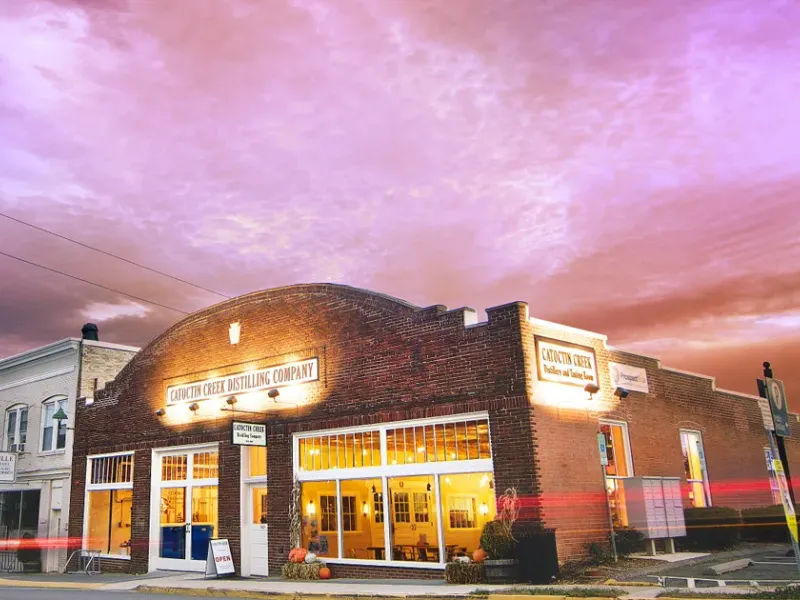 Street view of Catoctin Creek Distilling Company at dusk with a vivid sunset sky