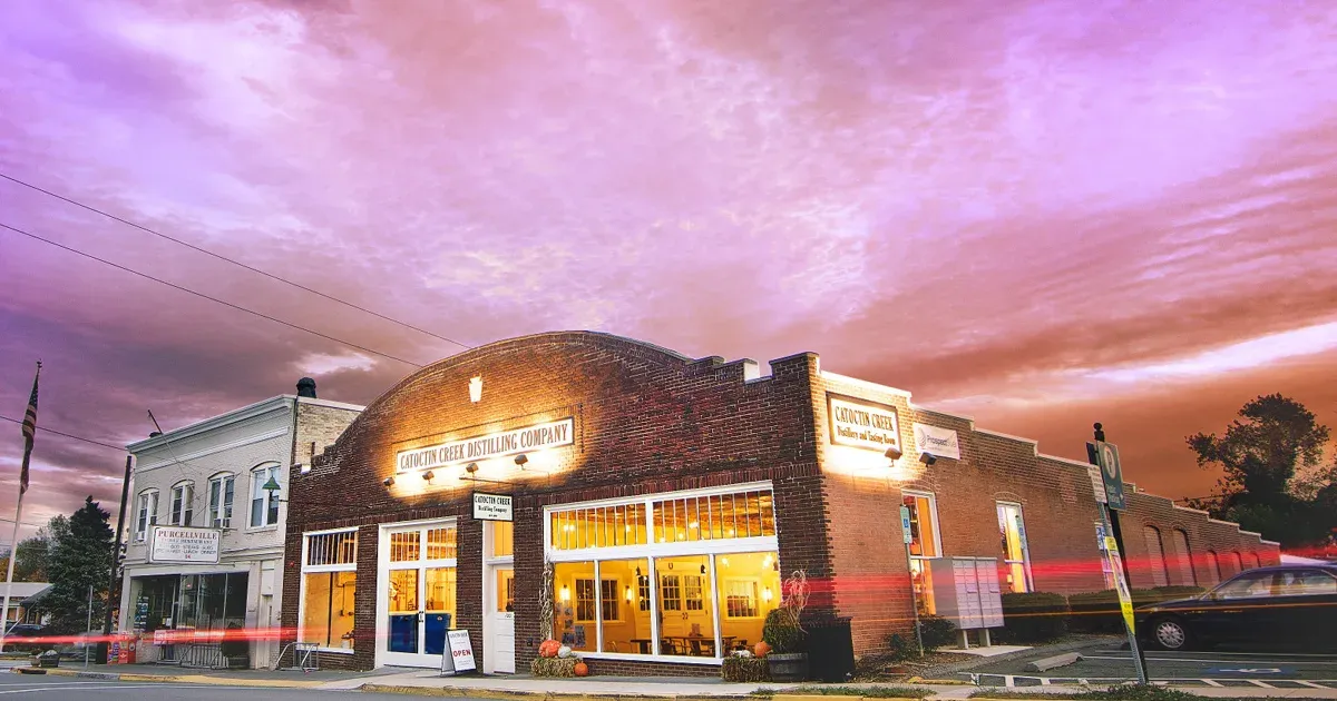 Street view of Catoctin Creek Distilling Company at dusk with a vivid sunset sky