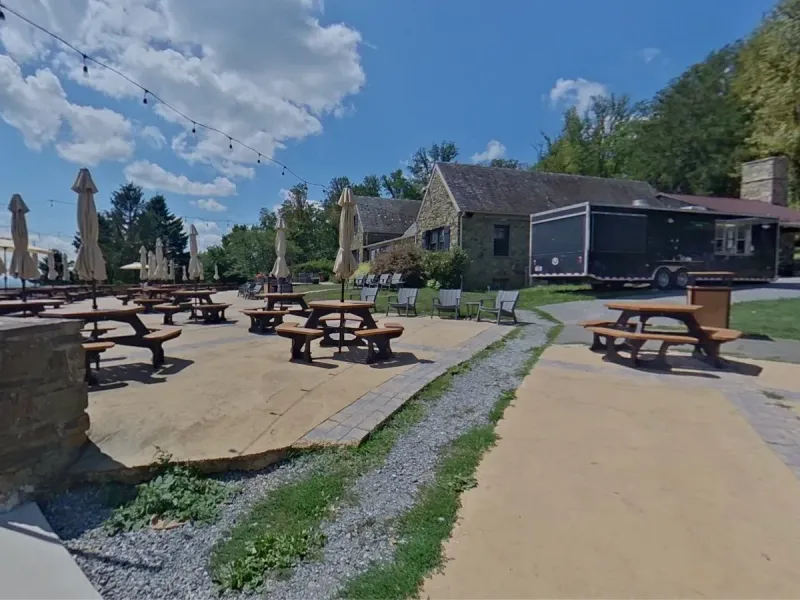 Dirt Farm Brewing patio with picnic tables and the stone brewery building