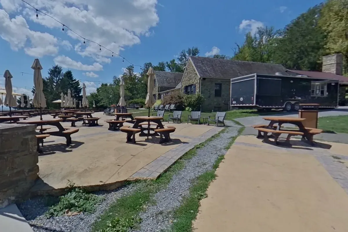 Dirt Farm Brewing patio with picnic tables and the stone brewery building