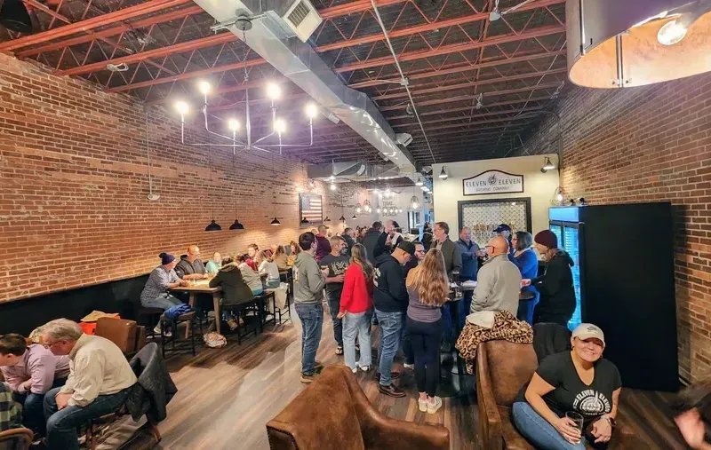 Eleven Eleven Brewing Company taproom with brick walls and guests