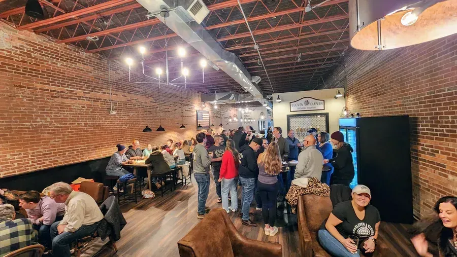 Eleven Eleven Brewing Company taproom with brick walls and guests