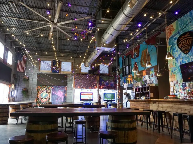 Ocelot Brewing Company taproom with string lights and barrel tables