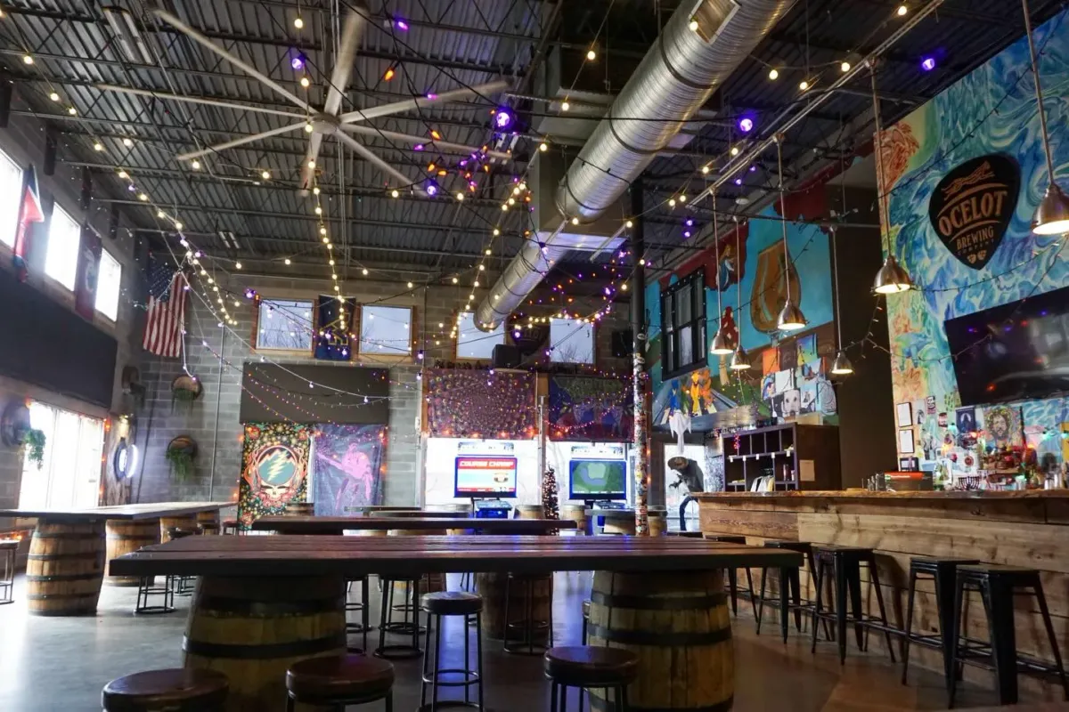 Ocelot Brewing Company taproom with string lights and barrel tables