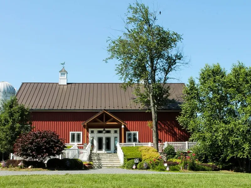Sunset Hills Vineyard red barn tasting room with silo and trees
