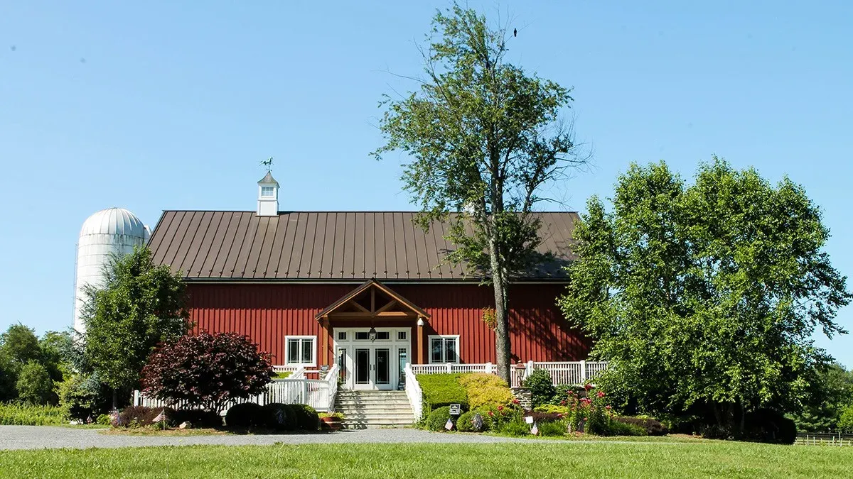 Sunset Hills Vineyard red barn tasting room with silo and trees
