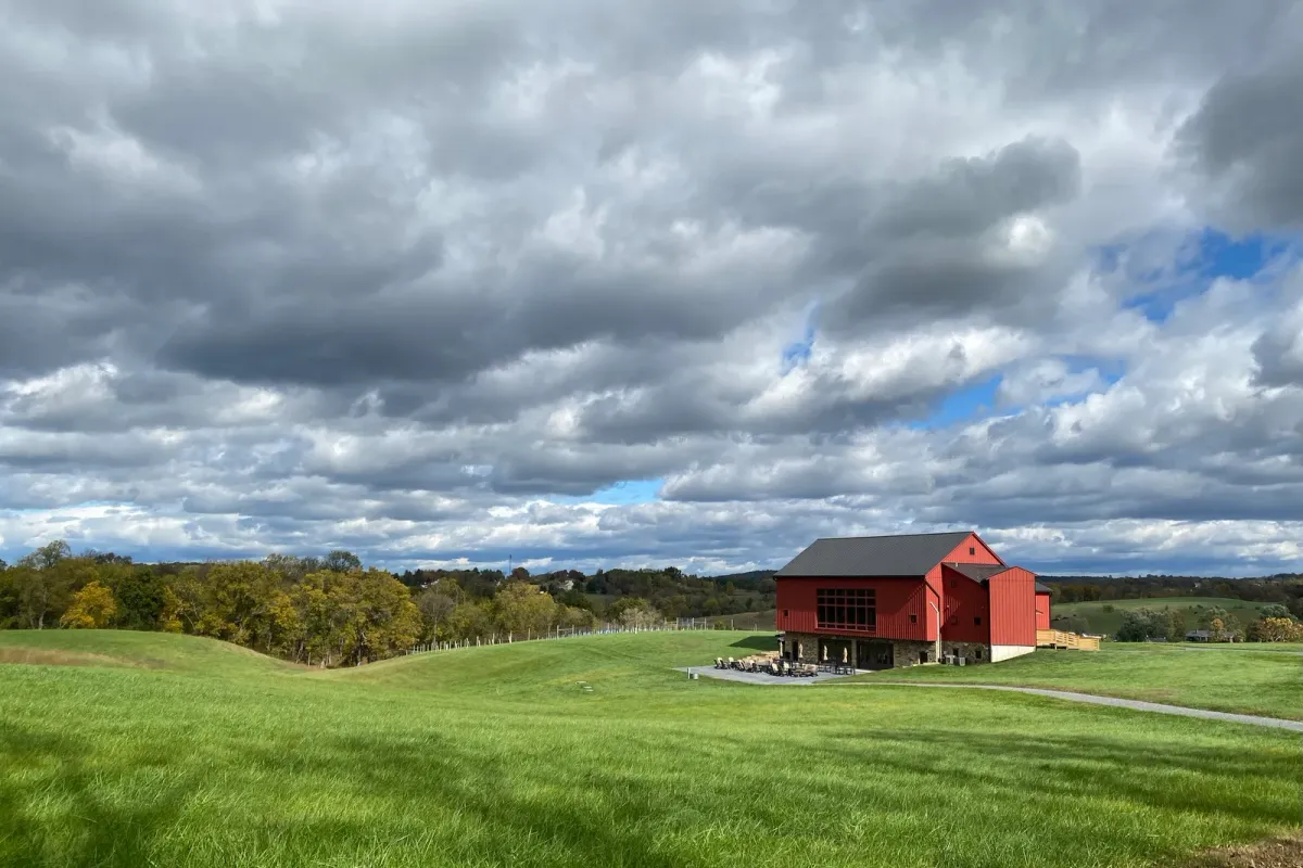 Terra Nebulo Vineyards red barn on rolling hills under dramatic clouds